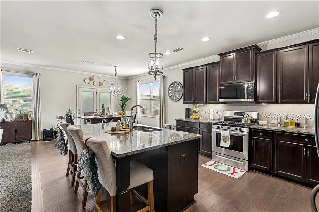 7284 Demeter Atlanta, GA 30349 - Photo 6 of 33 a kitchen with sink a stove and chairs
