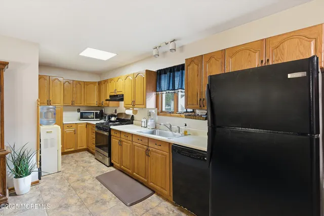 a kitchen with a sink stainless steel appliances and cabinets