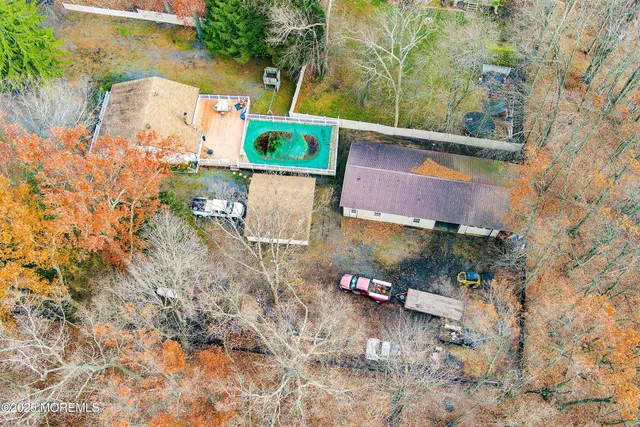 an aerial view of residential houses with outdoor space and trees