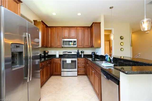 a kitchen with stainless steel appliances granite countertop a stove a sink and a refrigerator