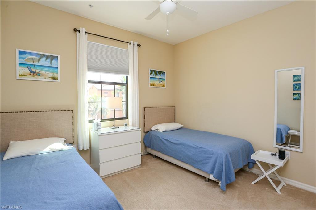 9082 Capistrano Street North, Unit 484 Naples, FL 34113 - Photo 22 of 35 a bedroom with a bed and a table in it
