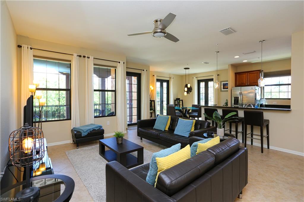 9082 Capistrano Street North, Unit 484 Naples, FL 34113 - Photo 4 of 35 a living room with furniture and floor to ceiling windows