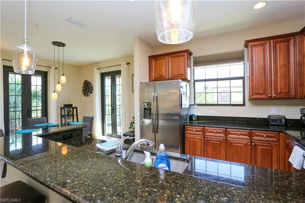 a kitchen with stainless steel appliances granite countertop sink stove and refrigerator