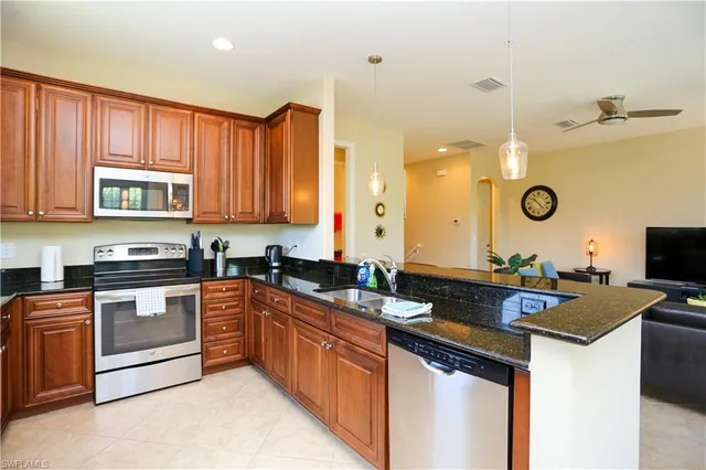 a kitchen with granite countertop a sink stove and cabinets