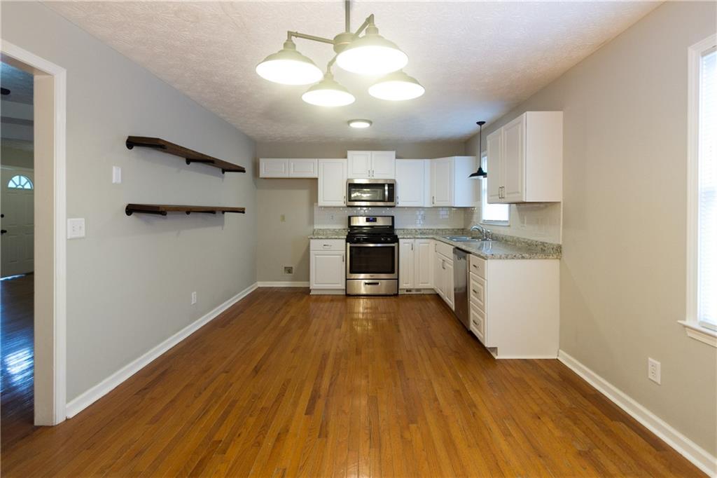 374 McGiboney Road Covington, GA 30016 - Photo 11 of 29 a kitchen with wooden floors and refrigerator