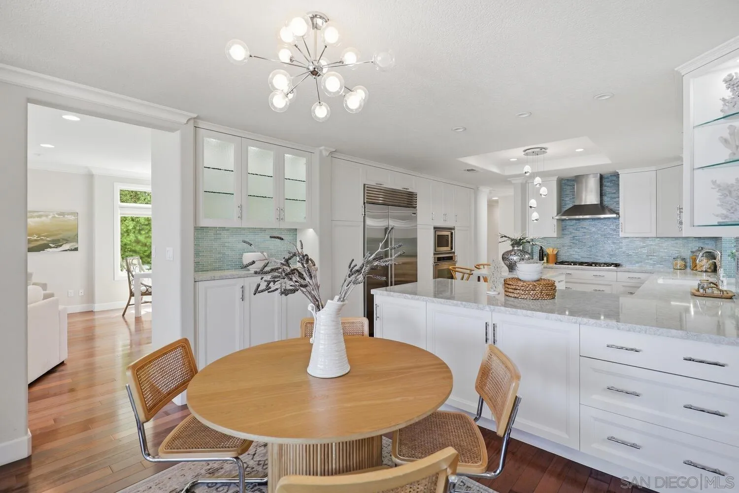 21 Spinnaker Way Coronado, CA 92118 - Photo 19 of 47 a dining room with wooden floor a chandelier a glass table and chairs