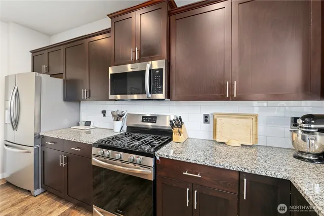 a kitchen with granite countertop cabinets stainless steel appliances and a counter space