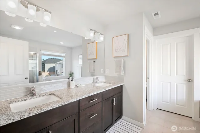 a bathroom with double vanity sinks and a mirror