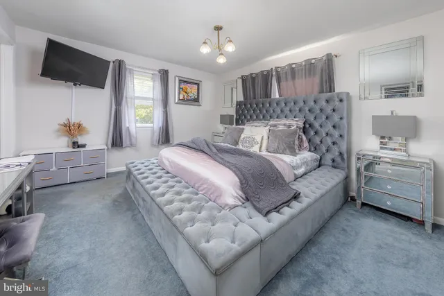 a spacious bedroom with a bed a couch and dresser