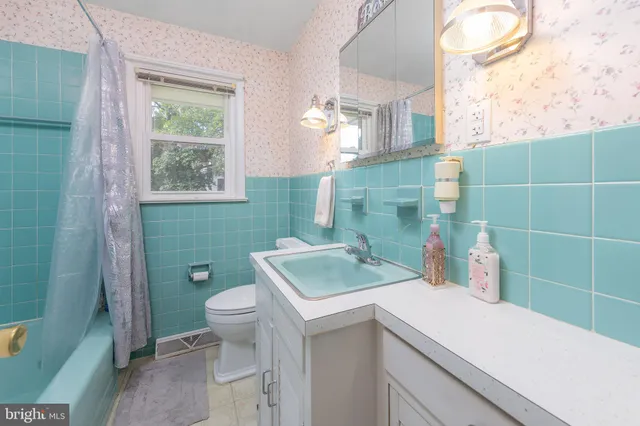 a bathroom with a sink toilet and window