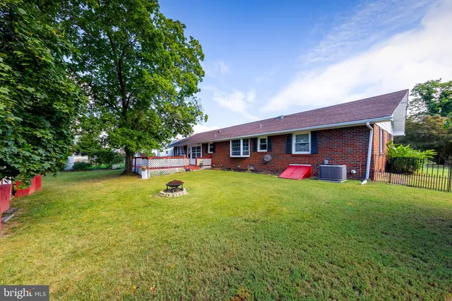 a front view of house with yard and trees in the background
