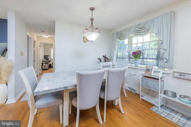 a dining room with furniture a chandelier and wooden floor