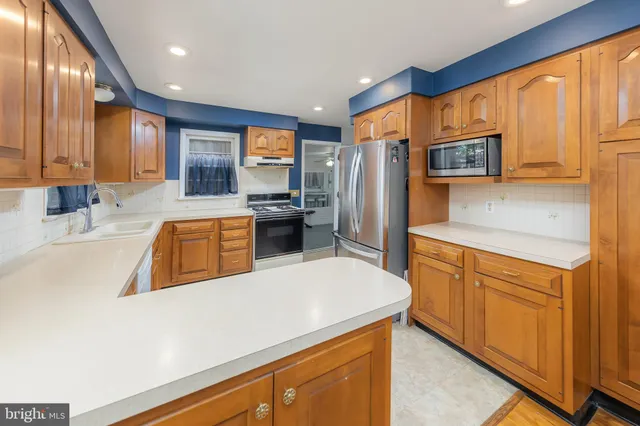 a kitchen with stainless steel appliances a sink dishwasher stove refrigerator and microwave