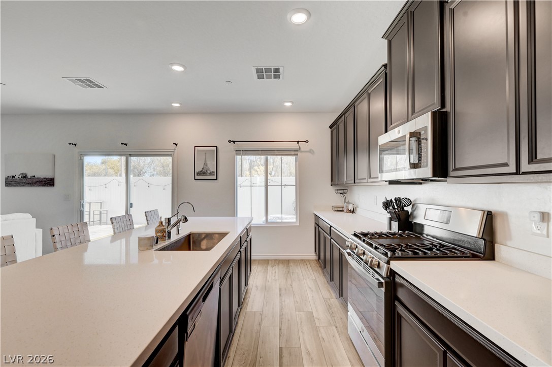 7204 North Decatur Boulevard, Unit 3 North Las Vegas, NV 89084 - Photo 13 of 48 A contemporary kitchen showcasing rich cabinetry, sleek countertops, and a full suite of appliances.