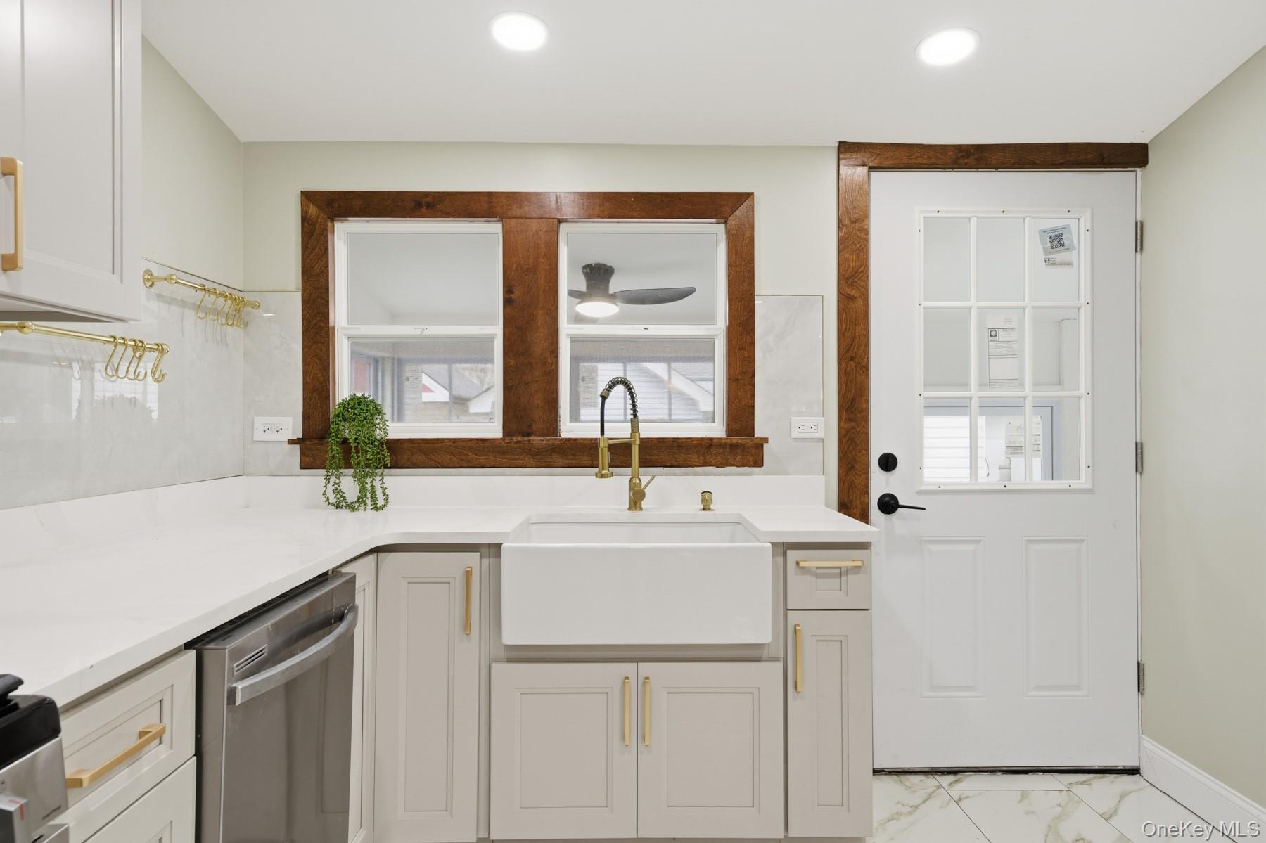 104-11 205th Street Queens, NY 11412 - Photo 16 of 50 Kitchen with dishwasher, light marble finish flooring, light stone countertops, white cabinets, and recessed lighting