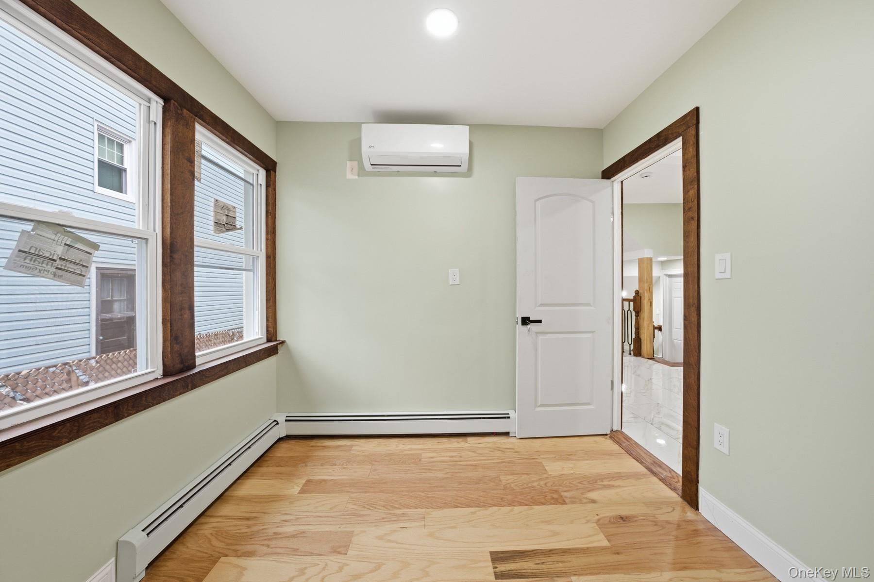 104-11 205th Street Queens, NY 11412 - Photo 19 of 50 Hallway with a baseboard radiator, light wood finished floors, and a wall unit AC