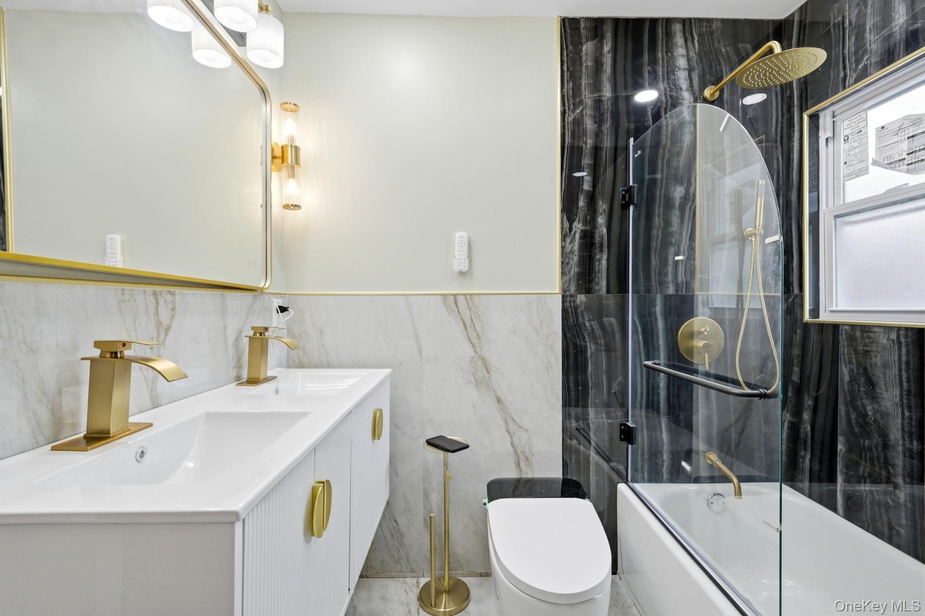 104-11 205th Street Queens, NY 11412 - Photo 22 of 50 Full bathroom featuring double vanity, tile walls, and a combined bath / shower with marble appearance