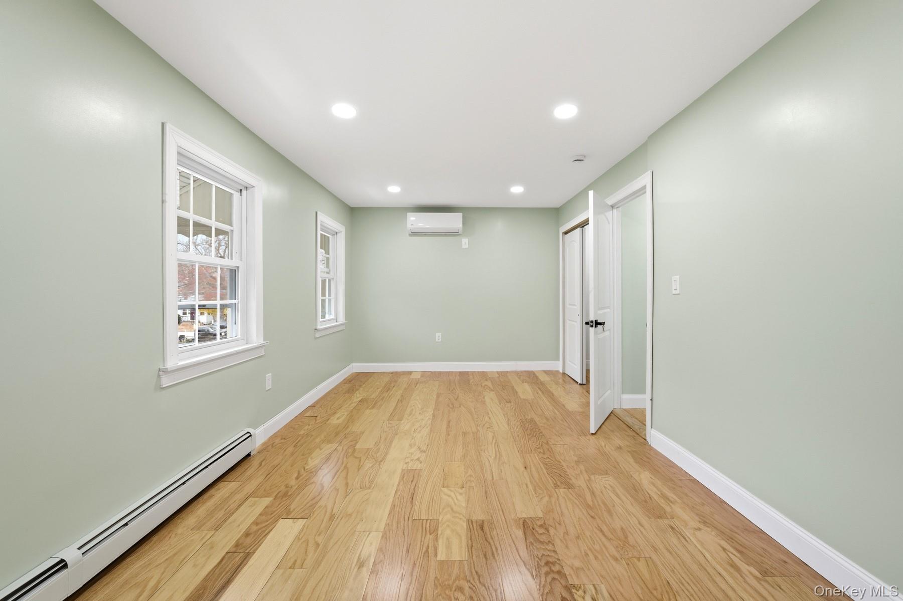 104-11 205th Street Queens, NY 11412 - Photo 30 of 50 Unfurnished room featuring a baseboard heating unit, light wood-type flooring, recessed lighting, and a wall mounted AC