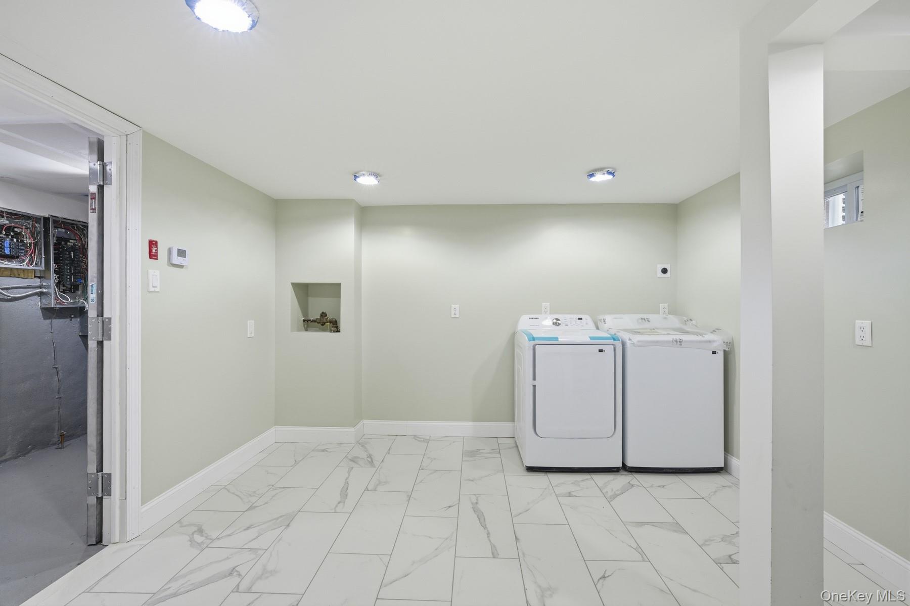 104-11 205th Street Queens, NY 11412 - Photo 39 of 50 Washroom featuring washer / dryer and light marble finish flooring