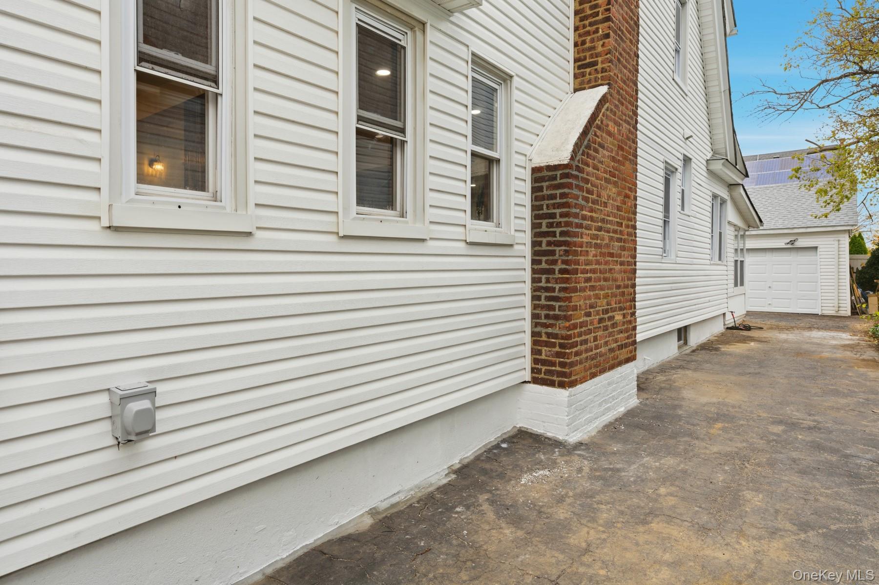 104-11 205th Street Queens, NY 11412 - Photo 50 of 50 View of side of home with driveway and a detached garage