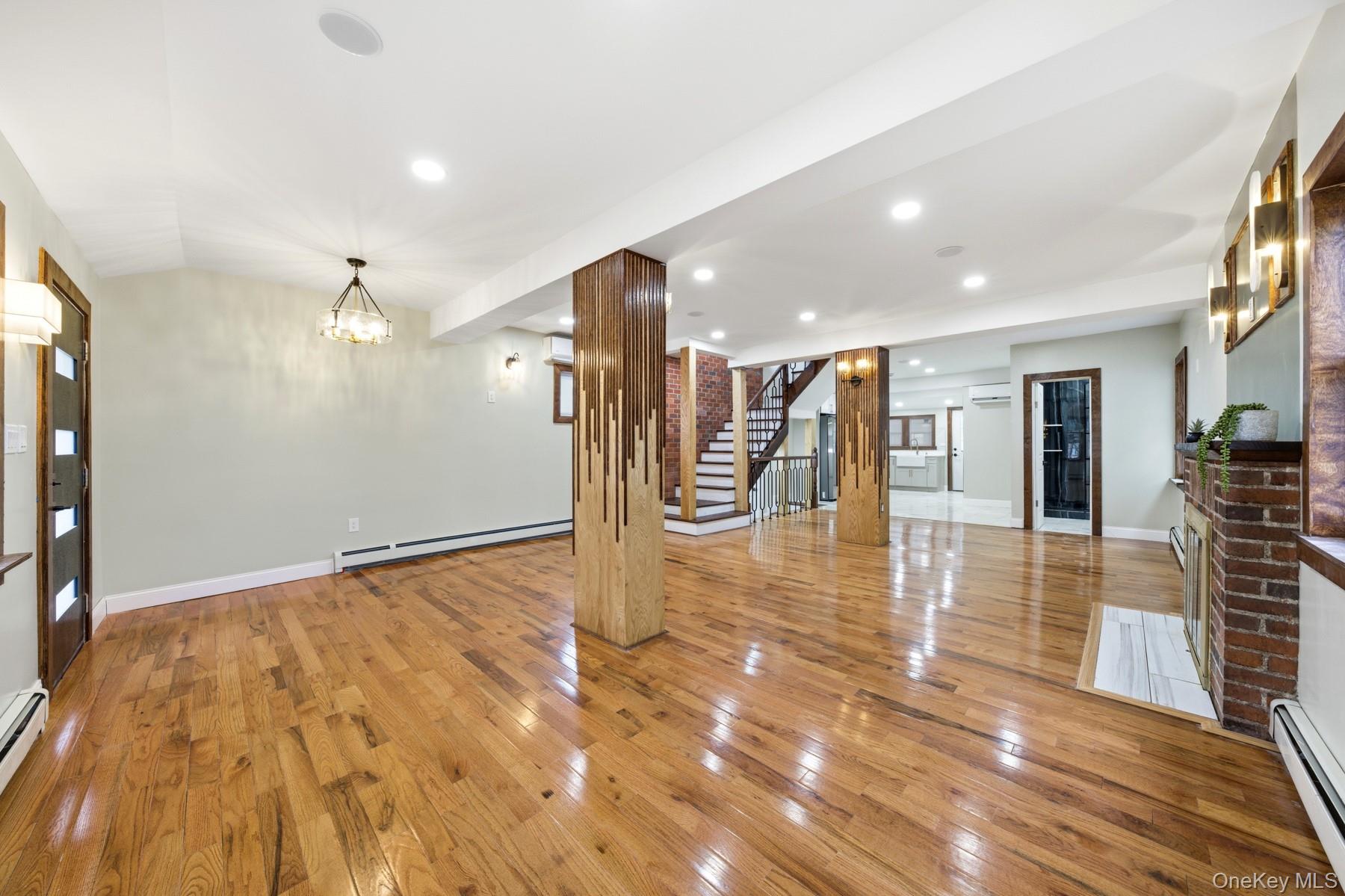 104-11 205th Street Queens, NY 11412 - Photo 5 of 50 Unfurnished living room featuring a chandelier, light wood-style flooring, a baseboard heating unit, and recessed lighting