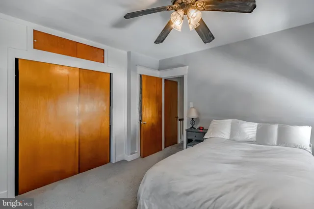 an empty room with wooden floor a ceiling fan and windows