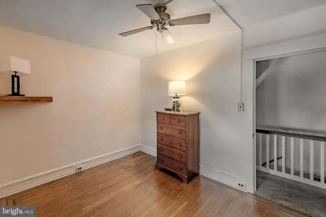 an empty room with wooden floor closet and windows
