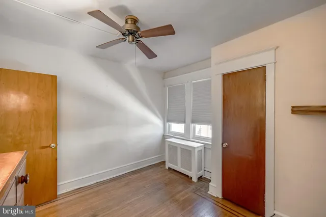 an empty room with a ceiling fan and window