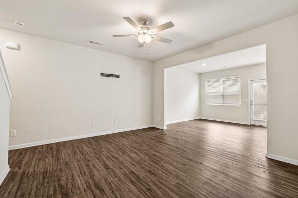 292 Whitetail Circle Canton, GA 30115 - Photo 3 of 17 an empty room with wooden floor chandelier fan and windows