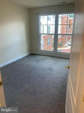 a view of a livingroom with an empty space and a window