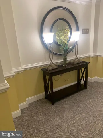 a living room with a table and a mirror