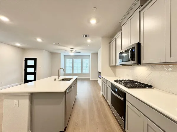 a kitchen with a sink a counter space and a refrigerator
