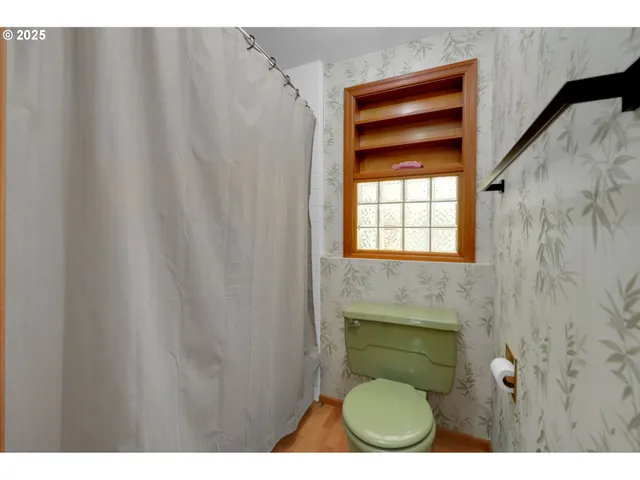 a bathroom with a toilet and a window