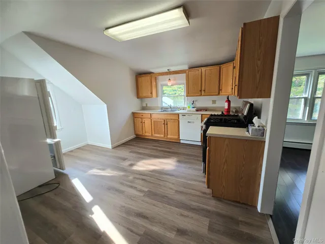 a kitchen with a sink wooden floor and black appliances