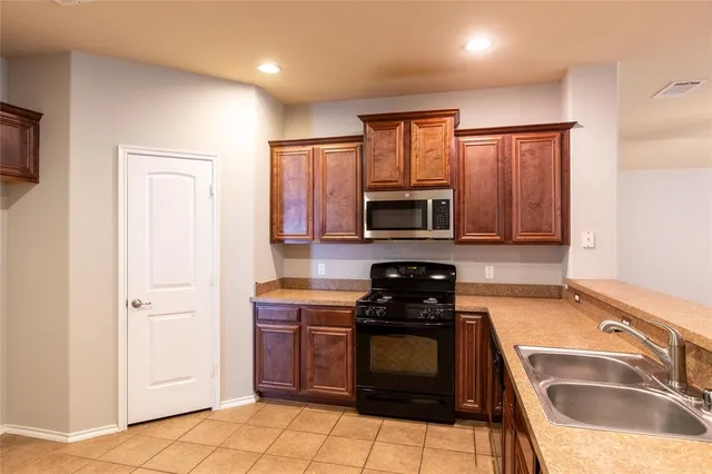 a kitchen with stainless steel appliances granite countertop a stove a sink and a microwave