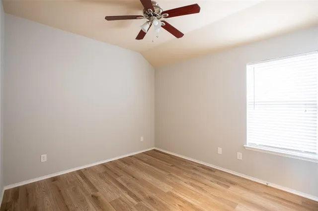 an empty room with a window and a fan
