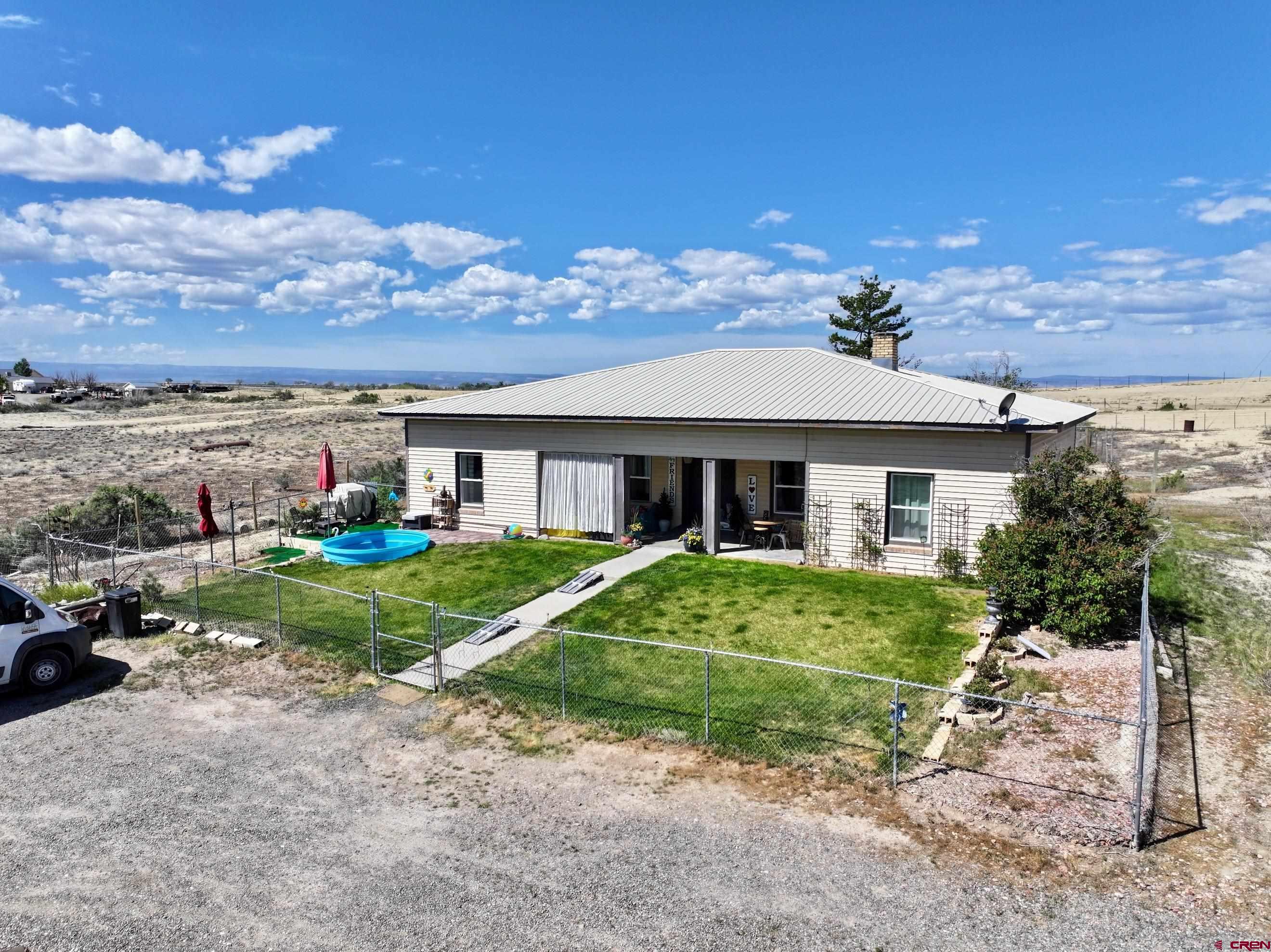 22244 F Road Delta, CO 81416 - Photo 2 of 41 a view of a big house with a big yard and potted plants