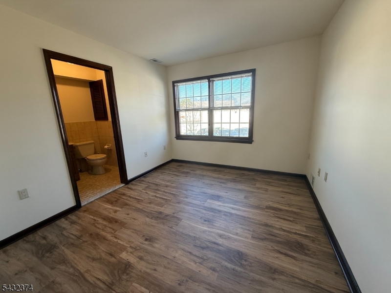 551 Valley Road, Unit 2 Montclair, NJ 07043 - Photo 3 of 9 an empty room with wooden floor and mirror