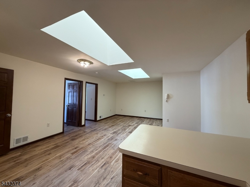 551 Valley Road, Unit 2 Montclair, NJ 07043 - Photo 5 of 9 an empty room with wooden floor and window