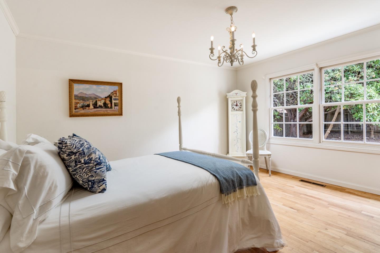 2952 Stevenson Drive Pebble Beach, CA 93953 - Photo 15 of 23 a spacious bedroom with a large bed chandelier and a window