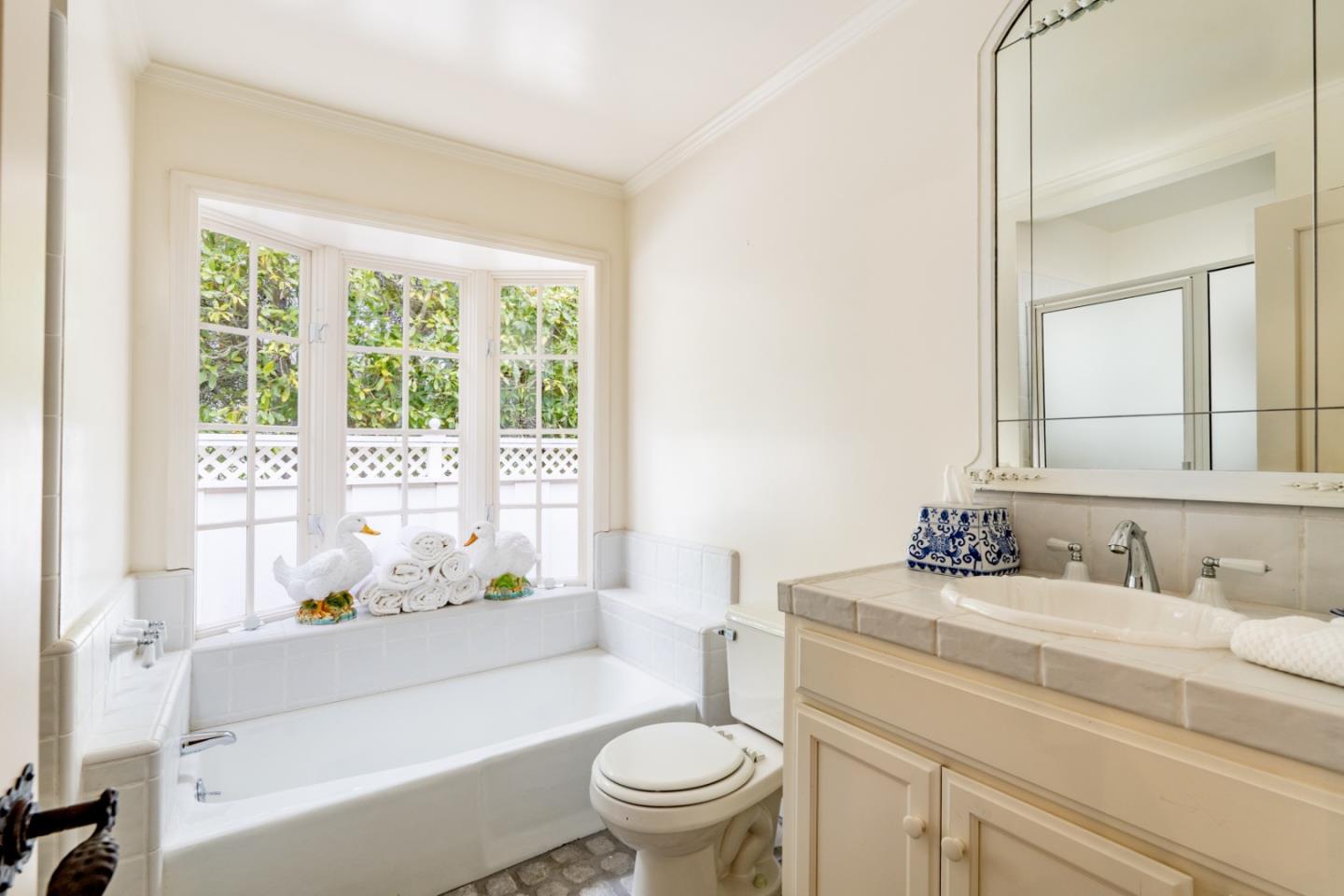 2952 Stevenson Drive Pebble Beach, CA 93953 - Photo 17 of 23 a bathroom with a sink a toilet a mirror a window and shower
