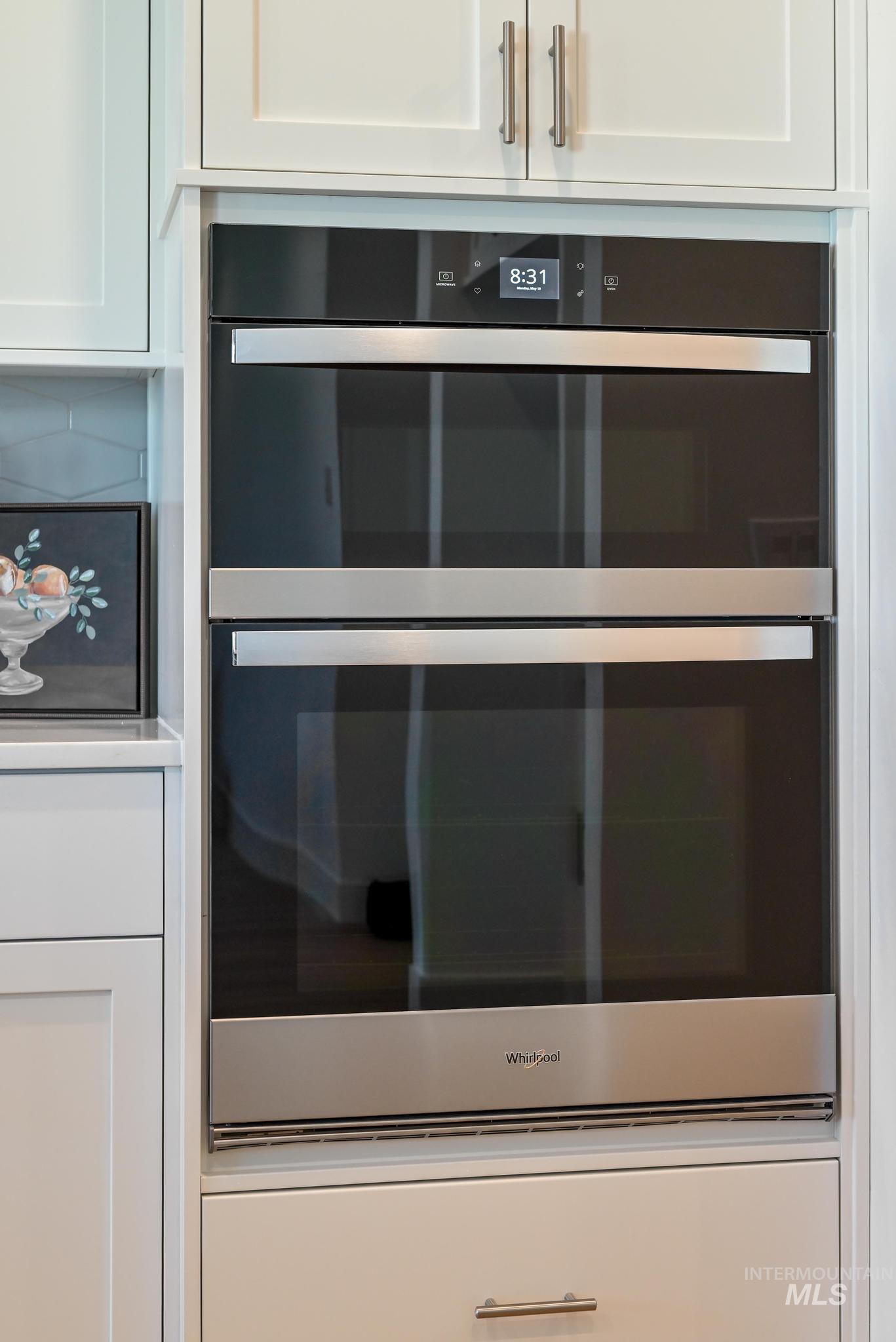 9074 West Moonglade Street Star, ID 83669 - Photo 13 of 40 Built-in double wall oven with stainless steel accents, integrated into white shaker-style cabinetry