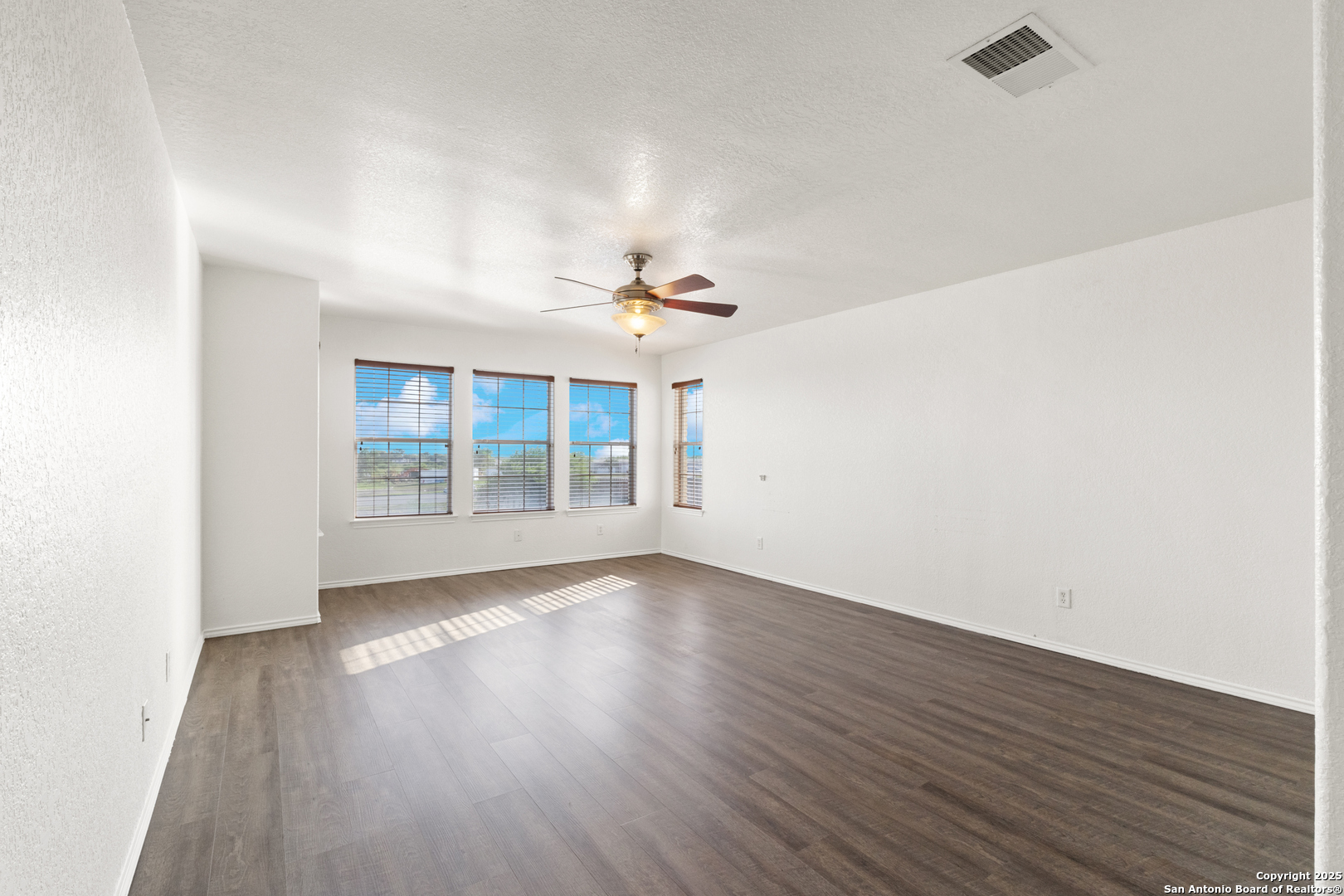11101 Baywave Live Oak, TX 78233 - Photo 29 of 38 an empty room with wooden floor chandelier fan and windows