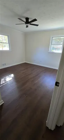 a view of a room with wooden floor and windows