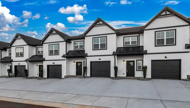 a front view of a house with a garage and a yard