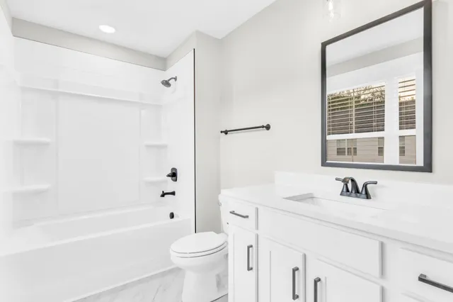 a bathroom with a sink a toilet a large mirror and shower