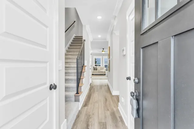 a view of a hallway with wooden floor and staircase