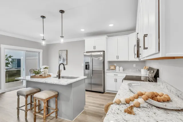 a kitchen with stainless steel appliances granite countertop a sink stove and refrigerator