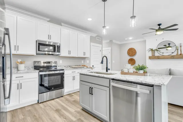 a kitchen with granite countertop cabinets stainless steel appliances and a wooden floor