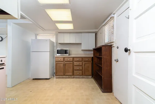 a kitchen with a refrigerator a stove top oven and cabinets